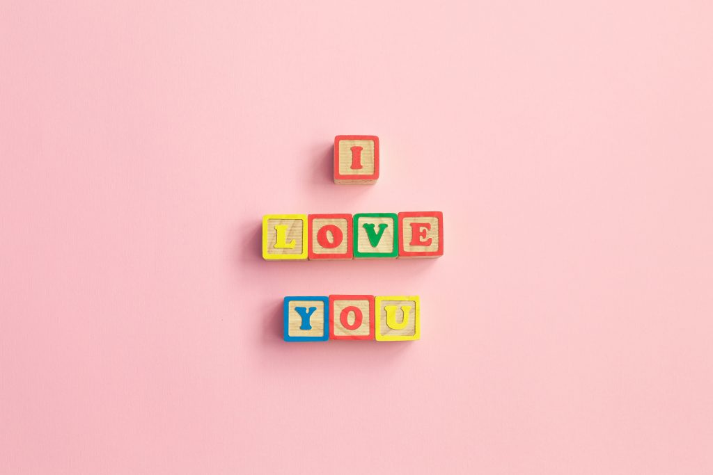 Message I love you spelled in wooden blocks. sign for relationships, romance, love and Valentines day, in letters with heart symbol. Mother's Day, Wedding Day, March 8, father's day